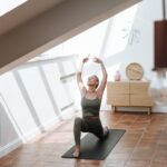 Woman stretching in a sunlit room at home