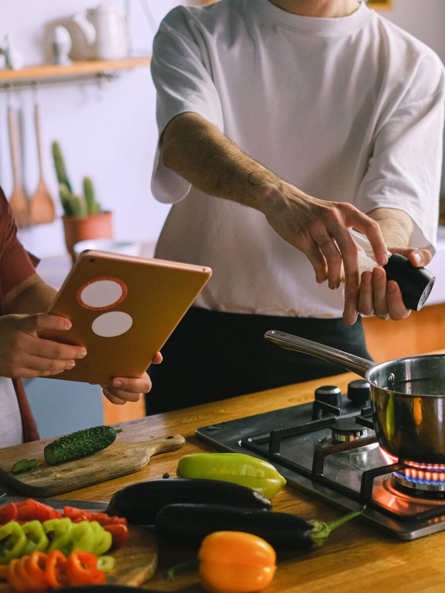Couple cooking a meal together and checking a tablet