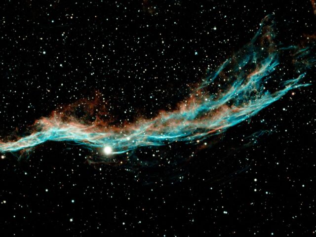 Veil Nebula filaments in cyan and gold across a dark sky