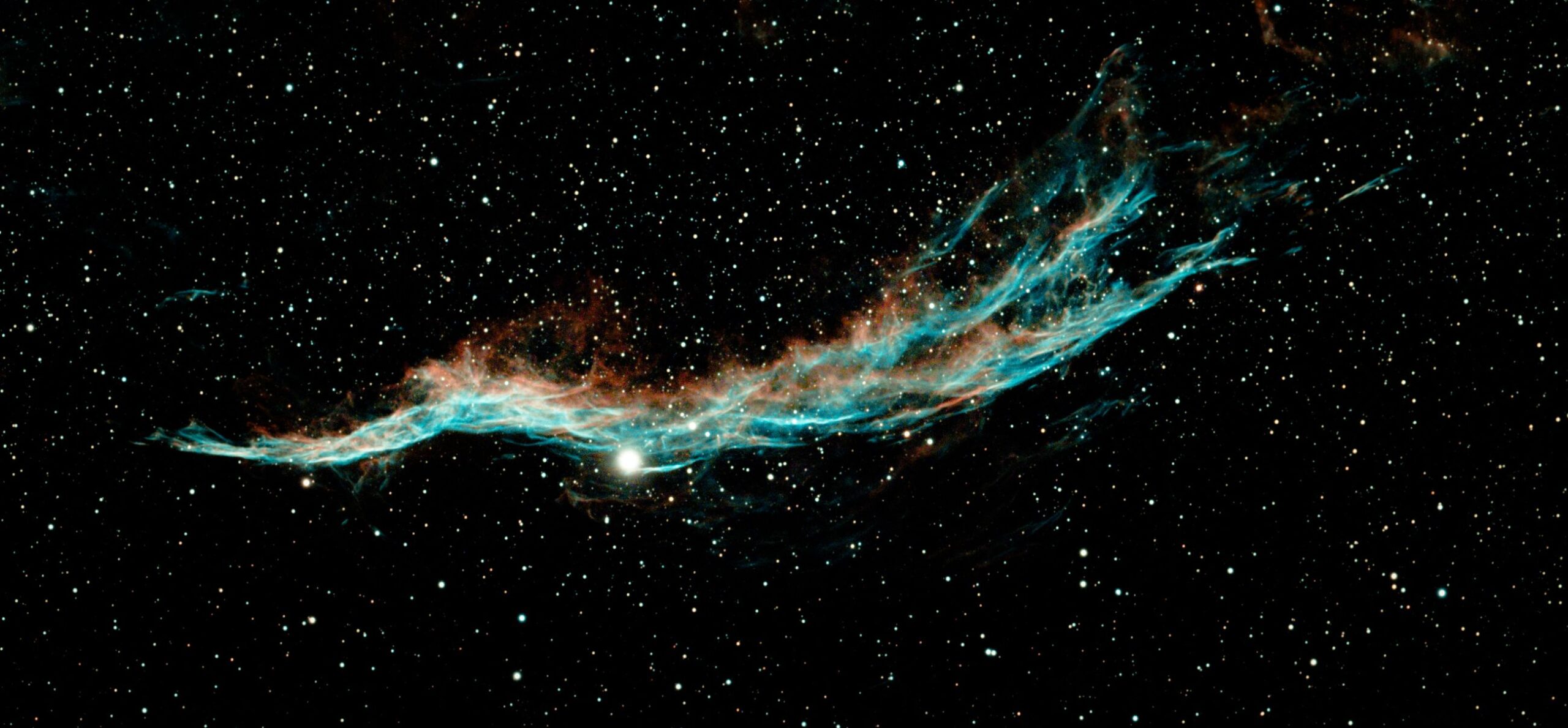 Veil Nebula filaments in cyan and gold across a dark sky