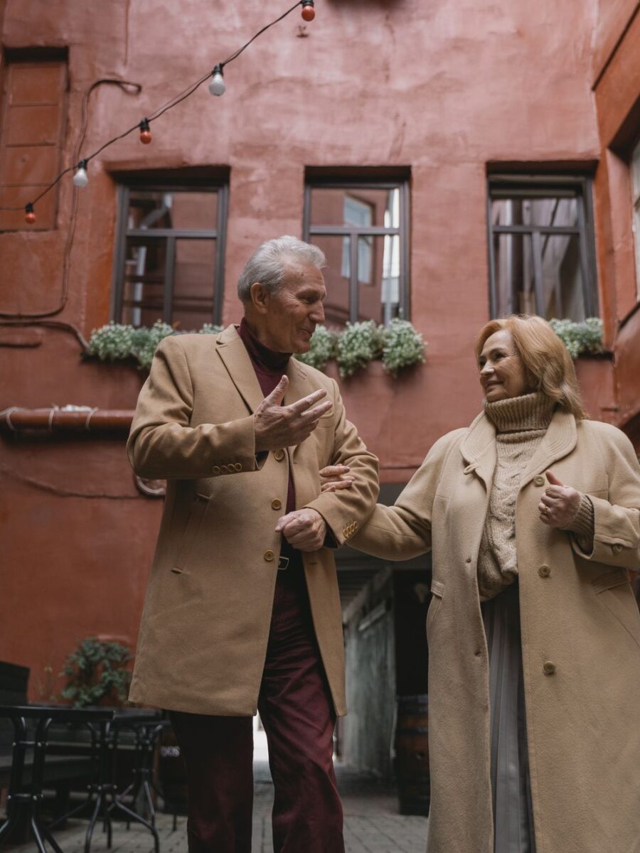 Older couple walking together through a city courtyard