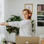Woman stretching by a window in her home office