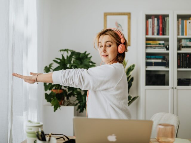 Woman stretching by a window in her home office