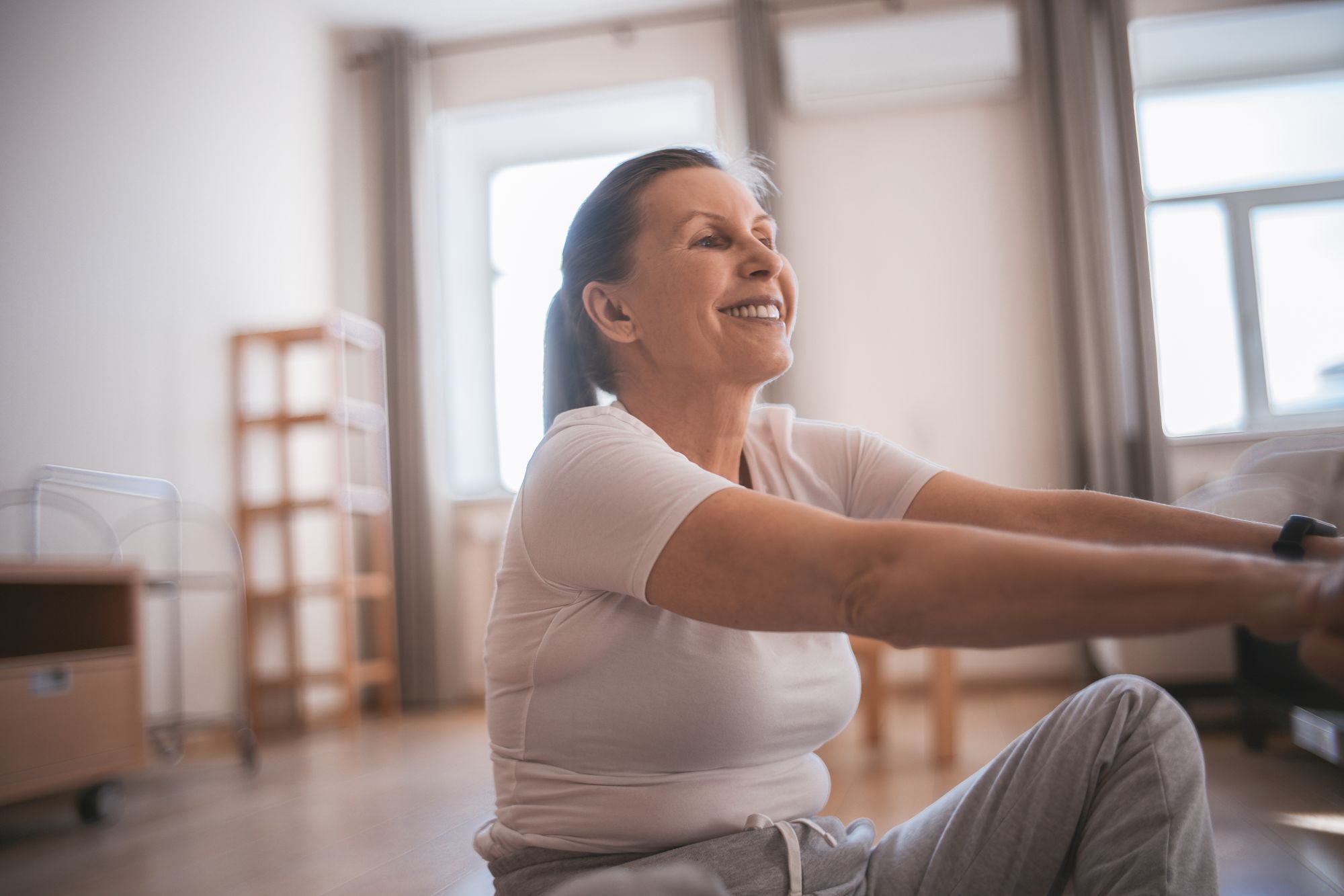 Mature woman exercising at home in natural light